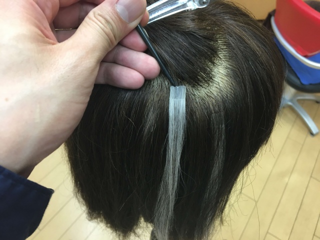 リングコームでシールエクステを外す写真