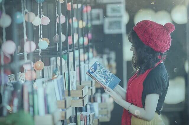 本を読む巻き髪の女性の写真