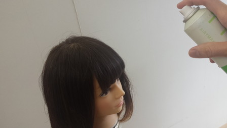 前髪にスプレーをかけている写真