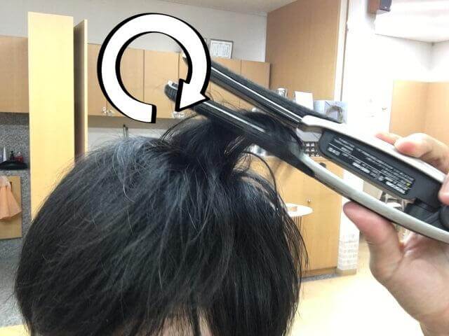 ストレートアイロンで髪の毛を内巻きにするところの写真