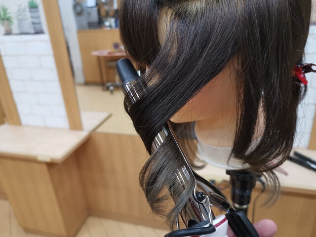 髪の毛束の真ん中に熱を当てる写真