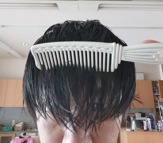 洗い流さないトリートメントをつけてとかしている髪