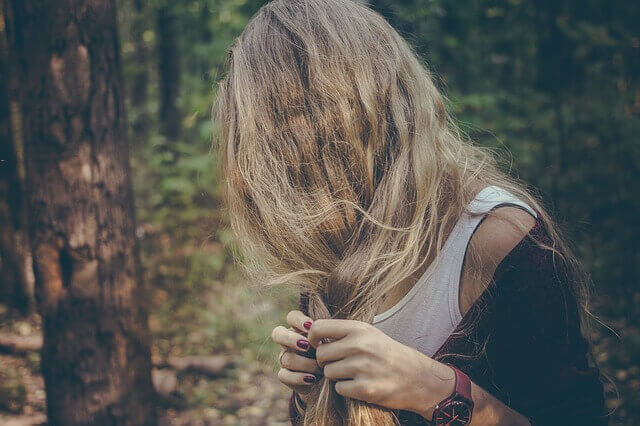 髪の毛の傷みを気にする女性の写真