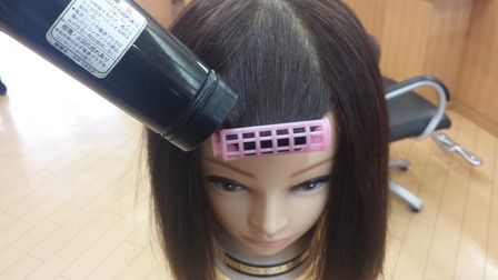 マジックカーラーで巻いた後にドライヤーで熱を当てている写真