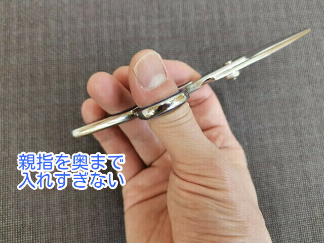 散髪ハサミの間違った親指の入れ方の写真