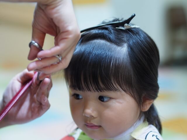 前髪をカットされる女の子の写真