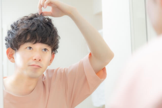 髪を気にする男性