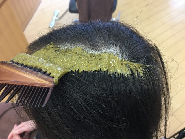 ヘナを髪の毛にぬっているところの写真