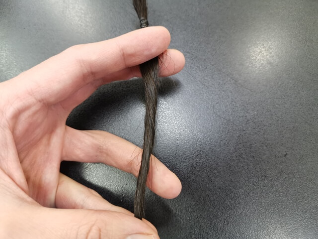 髪をひねってツイストさせている髪