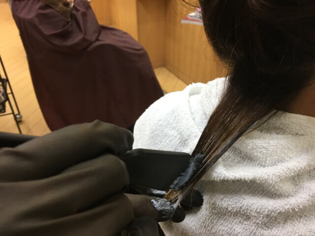 毛束の真ん中にブリーチを付ける写真