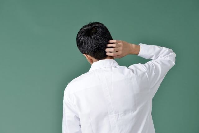 頭をかく男性