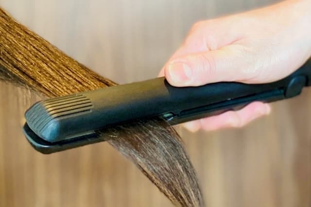 ヘアアイロンで髪を伸ばしている