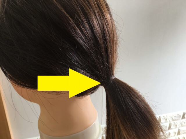 ヘアゴムで結んでいる髪の毛の写真矢印