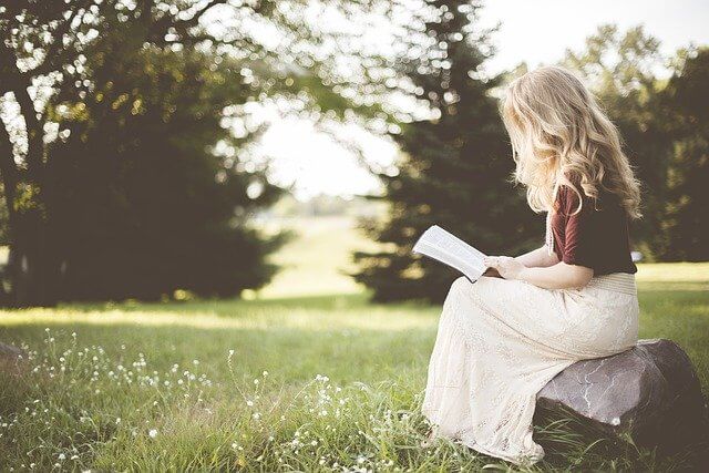本を読む明るい髪の女性