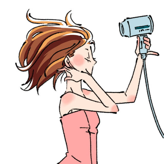ドライヤーを使っている女性の画像