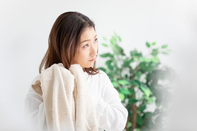 タオルで髪を拭く女性