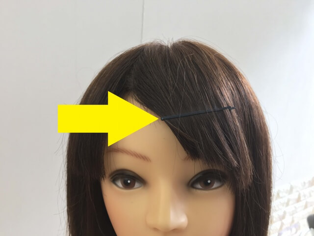 前髪をピンで止めている髪の毛の写真矢印