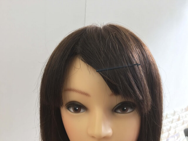 前髪をピンで止めている髪の毛の写真
