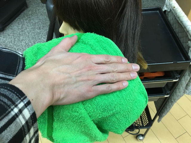 髪の毛をタオルで挟んで手で叩く写真