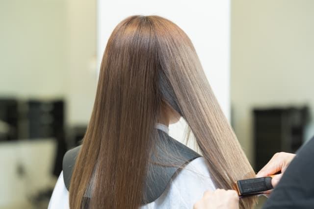 ヘアアイロンを使う美容師