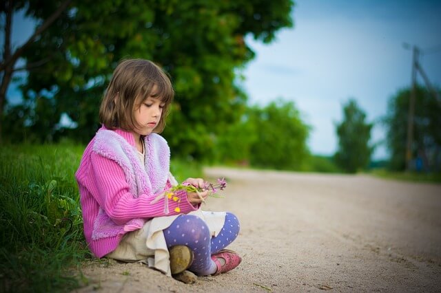 花を見つめる女の子の写真