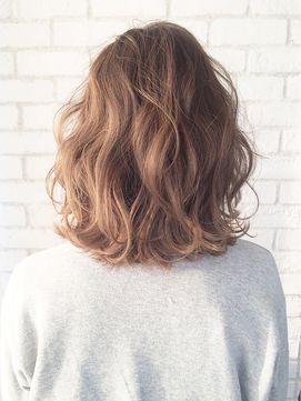 ウェーブヘアの女性の後ろ姿の写真