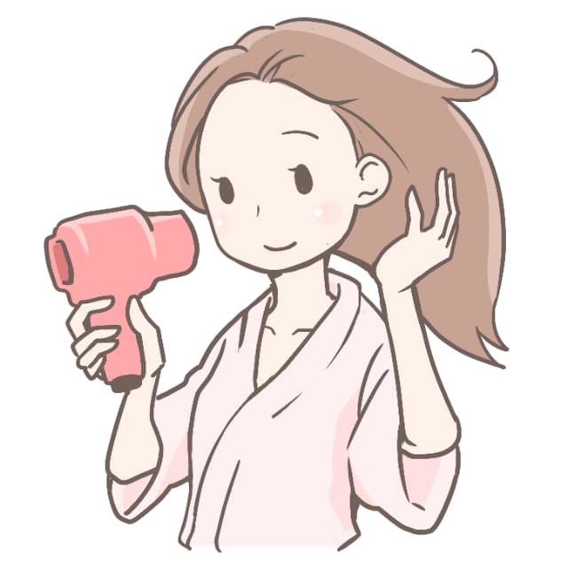 ドライヤーで髪を乾かす女性