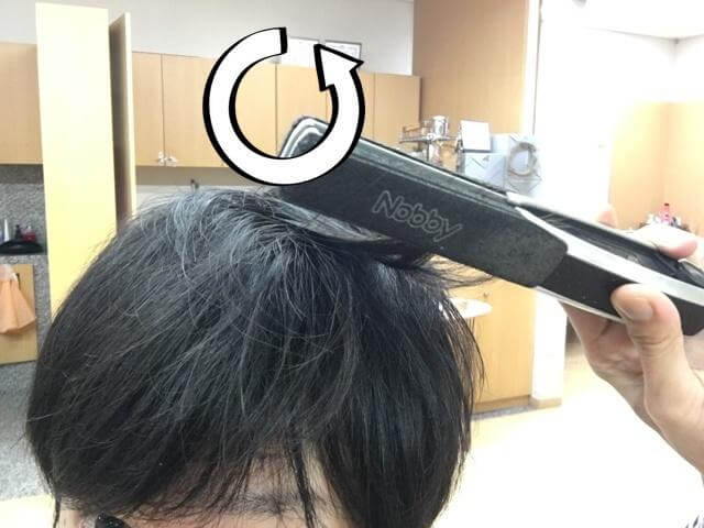 ストレートアイロンで外ハネをつくるところの写真