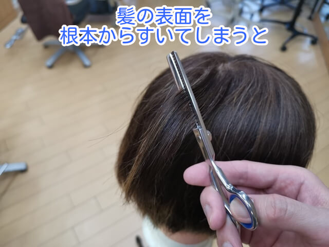 髪表面を根元からすいている写真